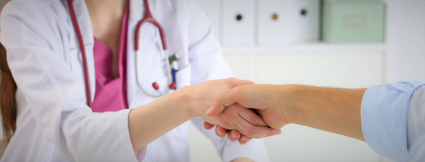 Female veterinarian in white coat shaking hands with business man